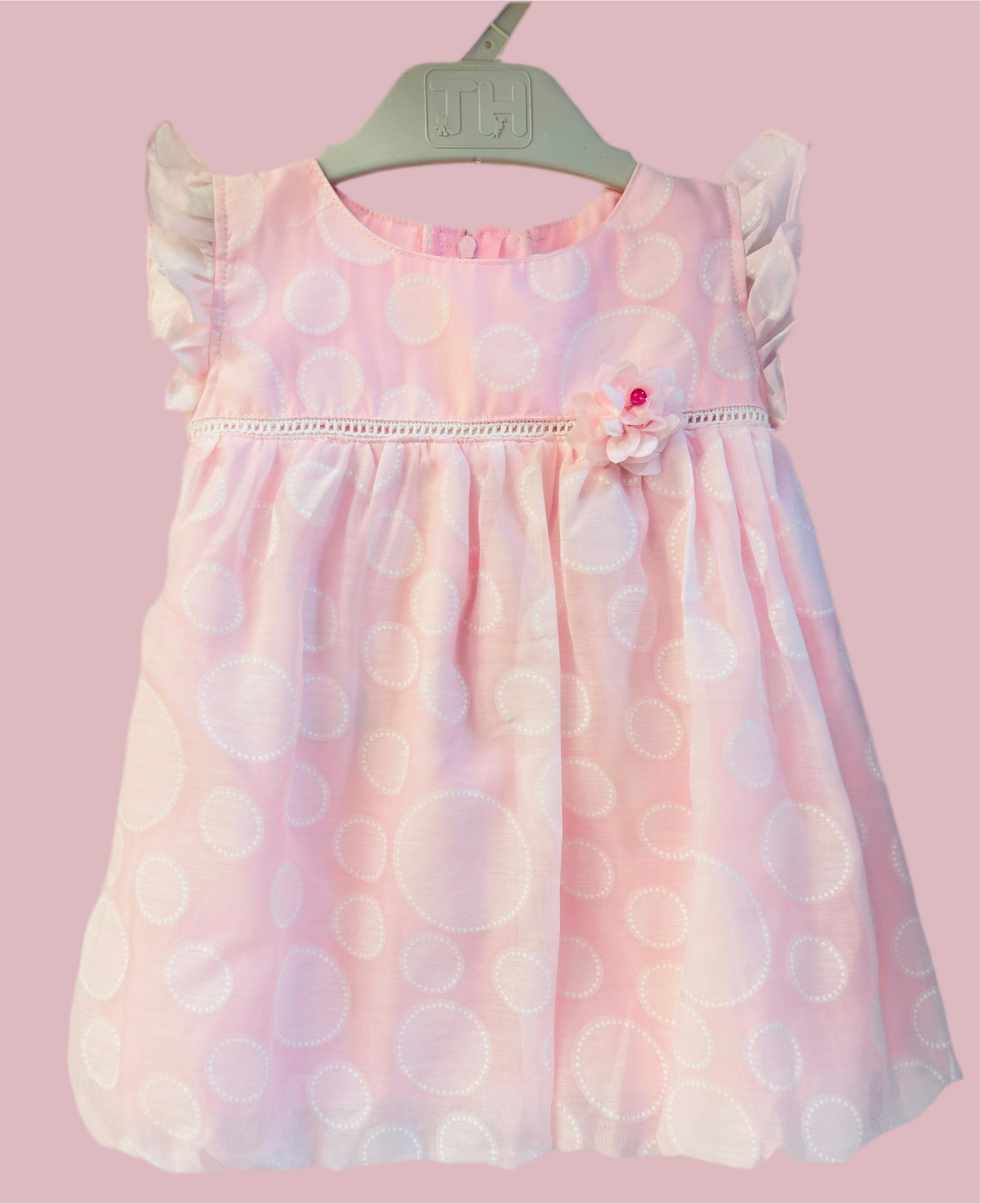 Luxe Thread pink polka dot baby dress with ruffled sleeves and floral accent for girls